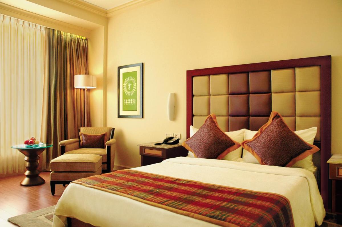 a hotel room with a large bed and a chair at Blue Diamond Pune IHCL SeleQtions in Pune