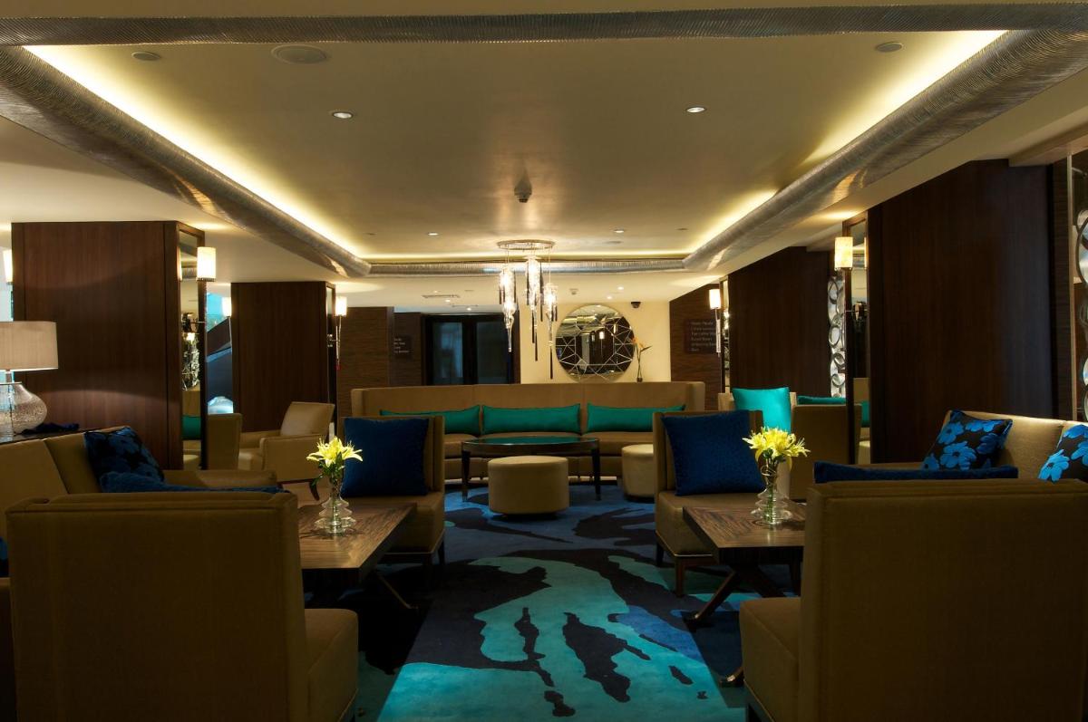 a hotel lobby with couches and tables and chairs at Blue Diamond Pune IHCL SeleQtions in Pune