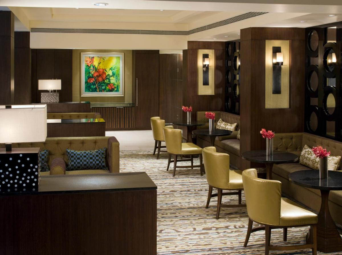 a lobby of a hotel with tables and chairs at Blue Diamond Pune IHCL SeleQtions in Pune