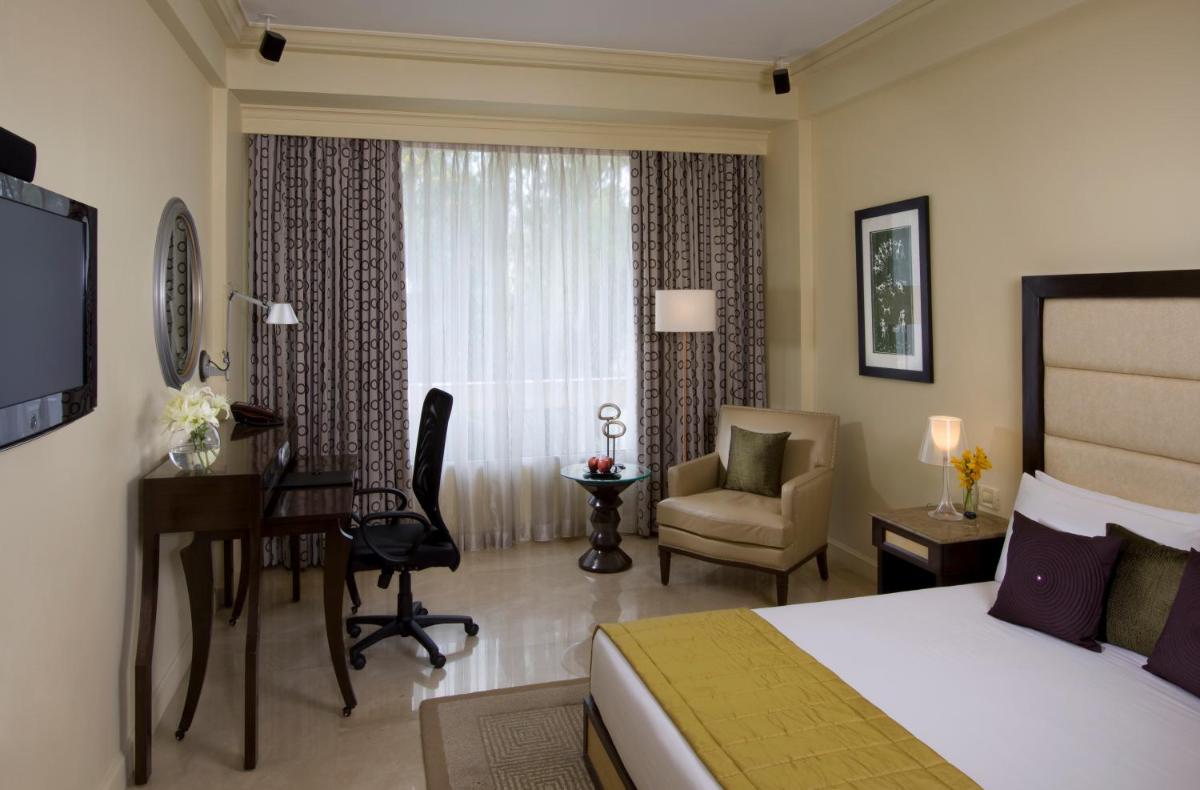 a hotel room with a bedroom with a bed and a desk at Blue Diamond Pune IHCL SeleQtions in Pune