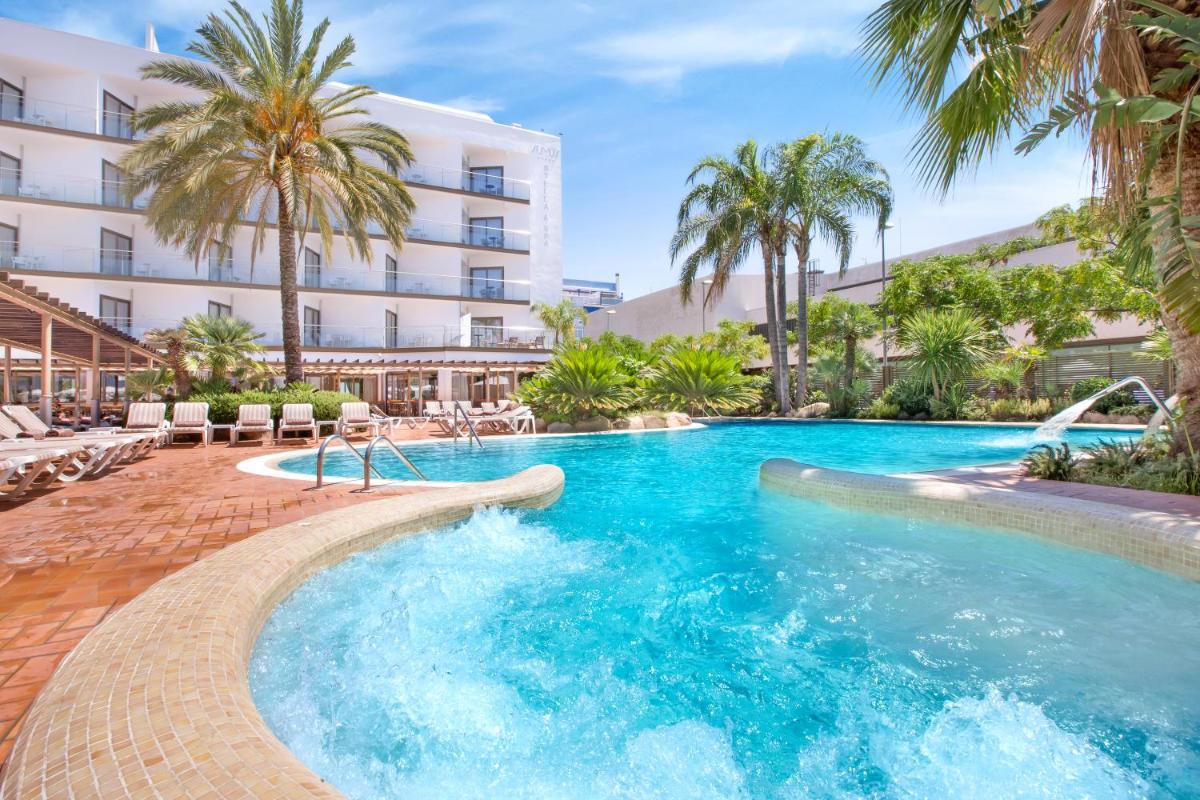 Una piscina frente a un hotel con palmeras. en Sumus Hotel Stella and Spa 4S Adults Recommended, en Pineda de Mar Una piscina frente a un hotel con palmeras. en Sumus Hotel Stella and Spa 4S Adults Recommended, en Pineda de Mar
