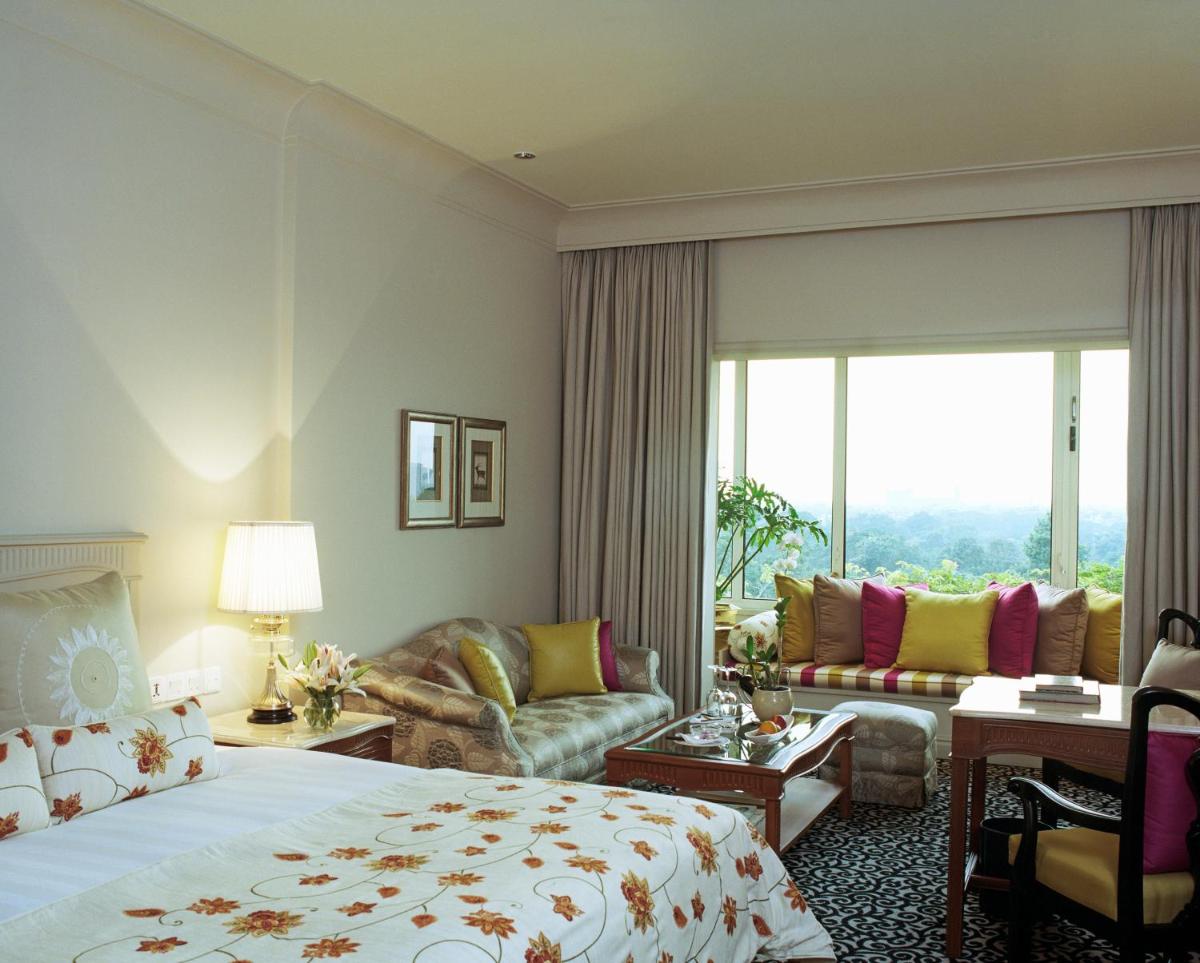 a hotel room with a king sized bed and a living room at Taj Bengal in Kolkata
