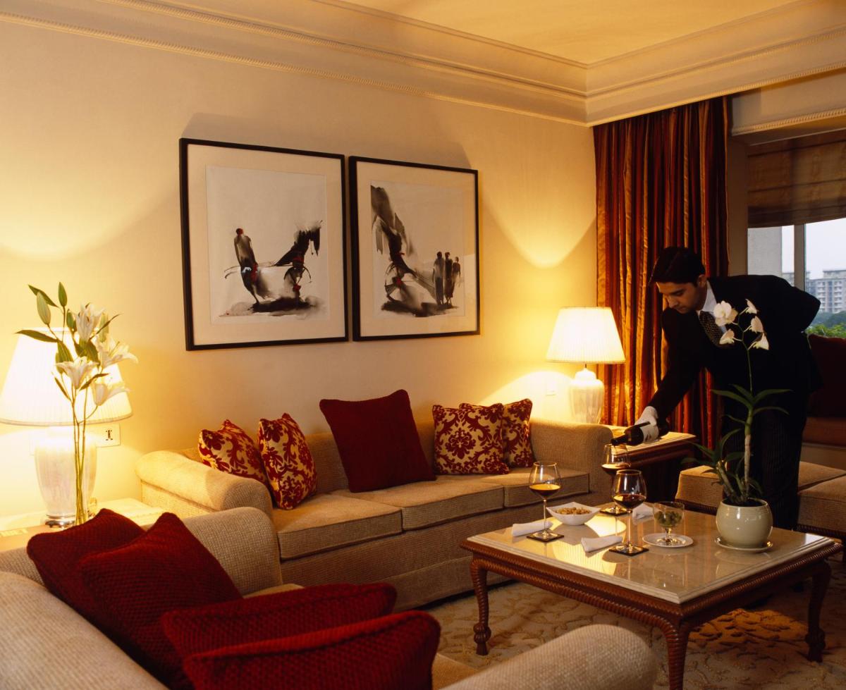 a woman standing in a living room with a couch at Taj Bengal in Kolkata