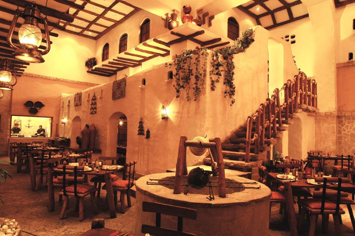 a restaurant with tables and chairs in a room at Taj Bengal in Kolkata