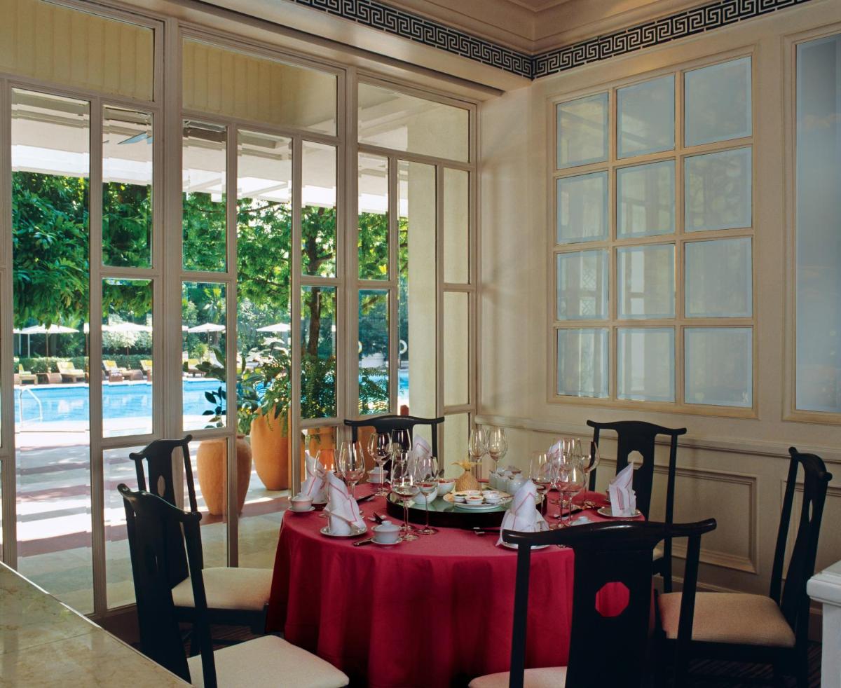 a dining room with a table with a red table cloth at Taj Bengal in Kolkata