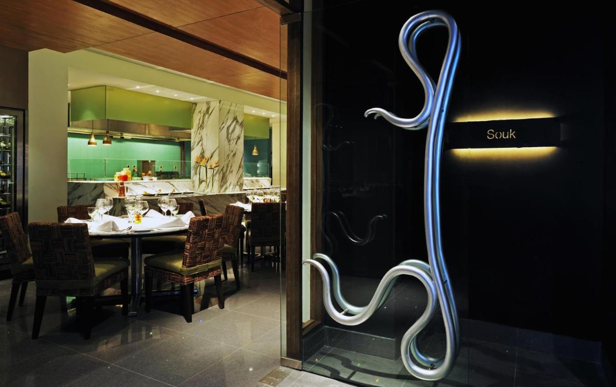 a restaurant with a dining table and a sign on the door at Taj Bengal in Kolkata