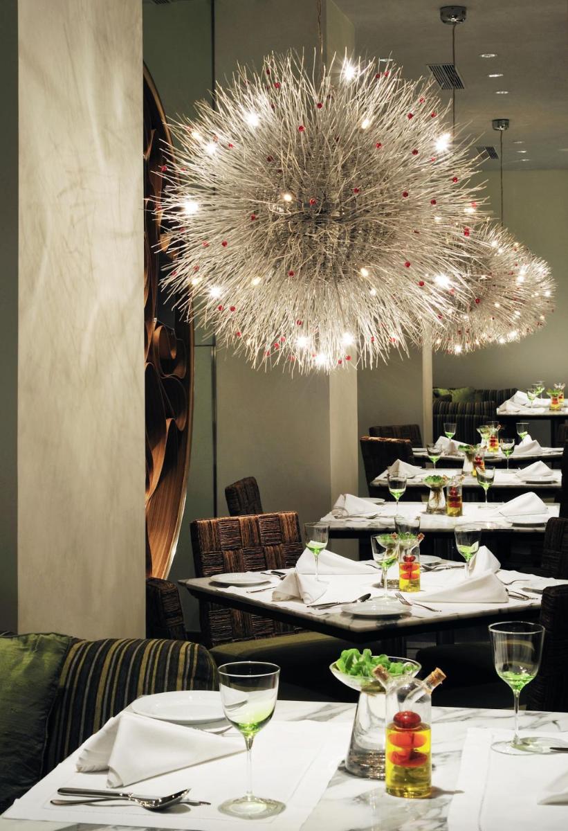 a dining room with white tables and a chandelier at Taj Bengal in Kolkata