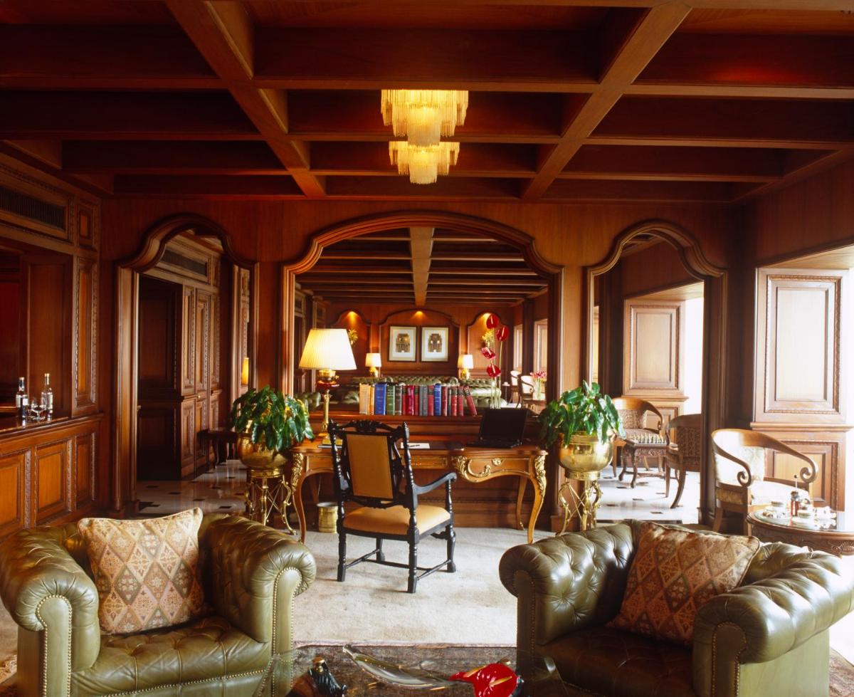 a living room with leather couches and a dining room at Taj Bengal in Kolkata