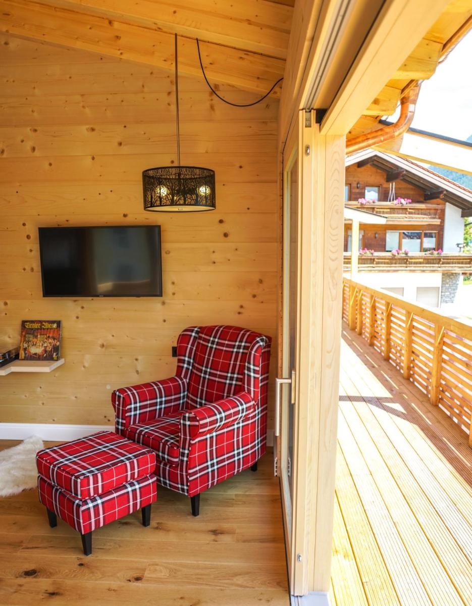eine Veranda mit einem Stuhl und einem TV in der Unterkunft Design Hotel ALPENLIEBE - - - - Boutique-Flair - - - - in Inzell