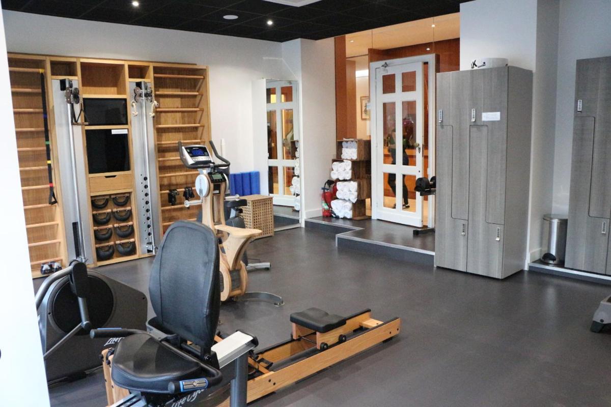 une salle de sport avec un tapis roulant et une chaise dans une pièce dans l'établissement Splendid Hotel & Spa Nice, à Nice