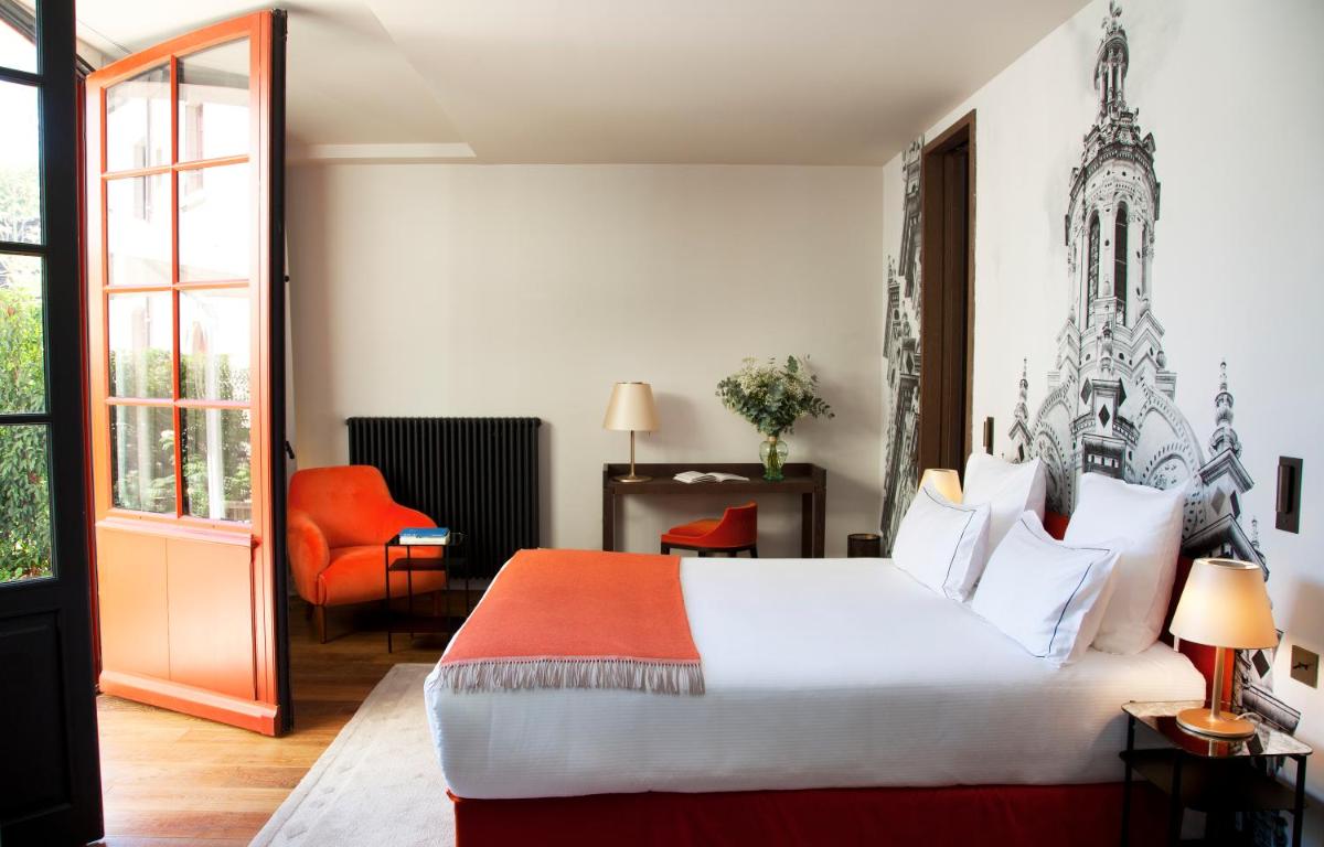 une chambre d'hôtel avec un lit et une chaise rouge dans l'établissement Relais de Chambord, a Small Luxury Hotels of the World, à Chambord
