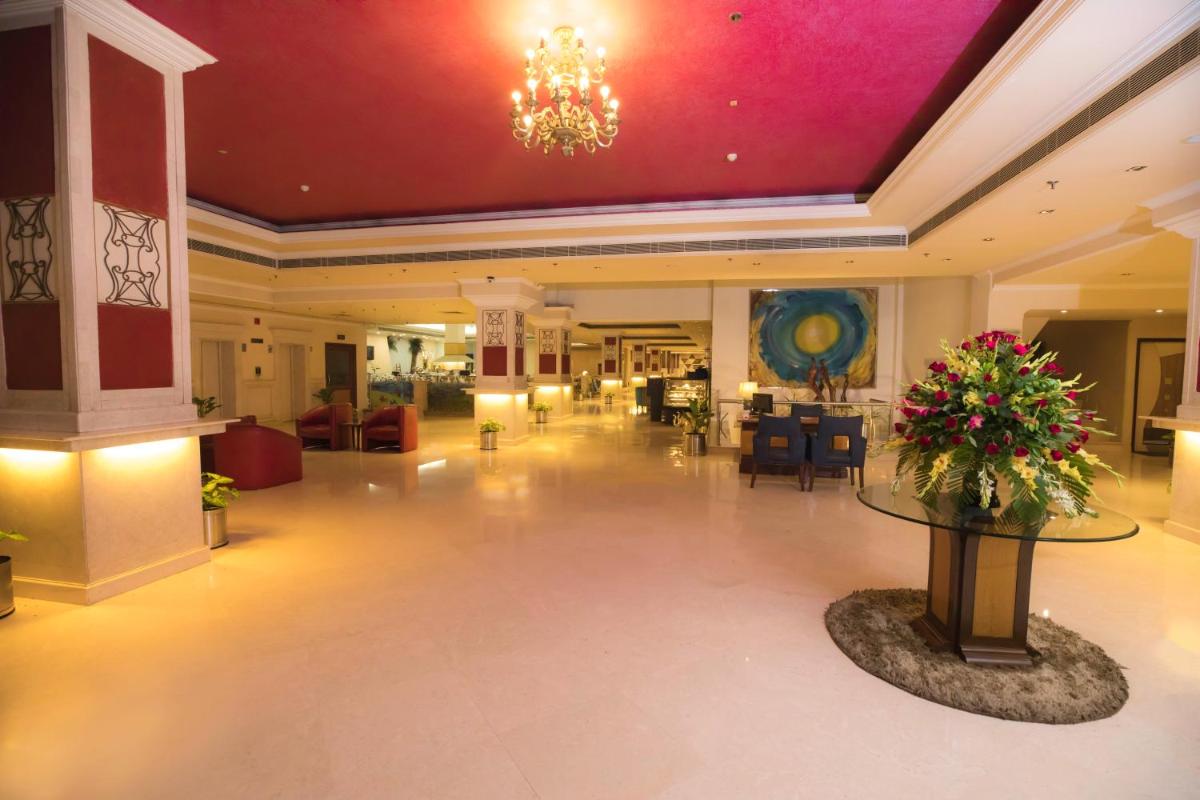 a lobby of a hotel with a chandelier at The Piccadily in Lucknow