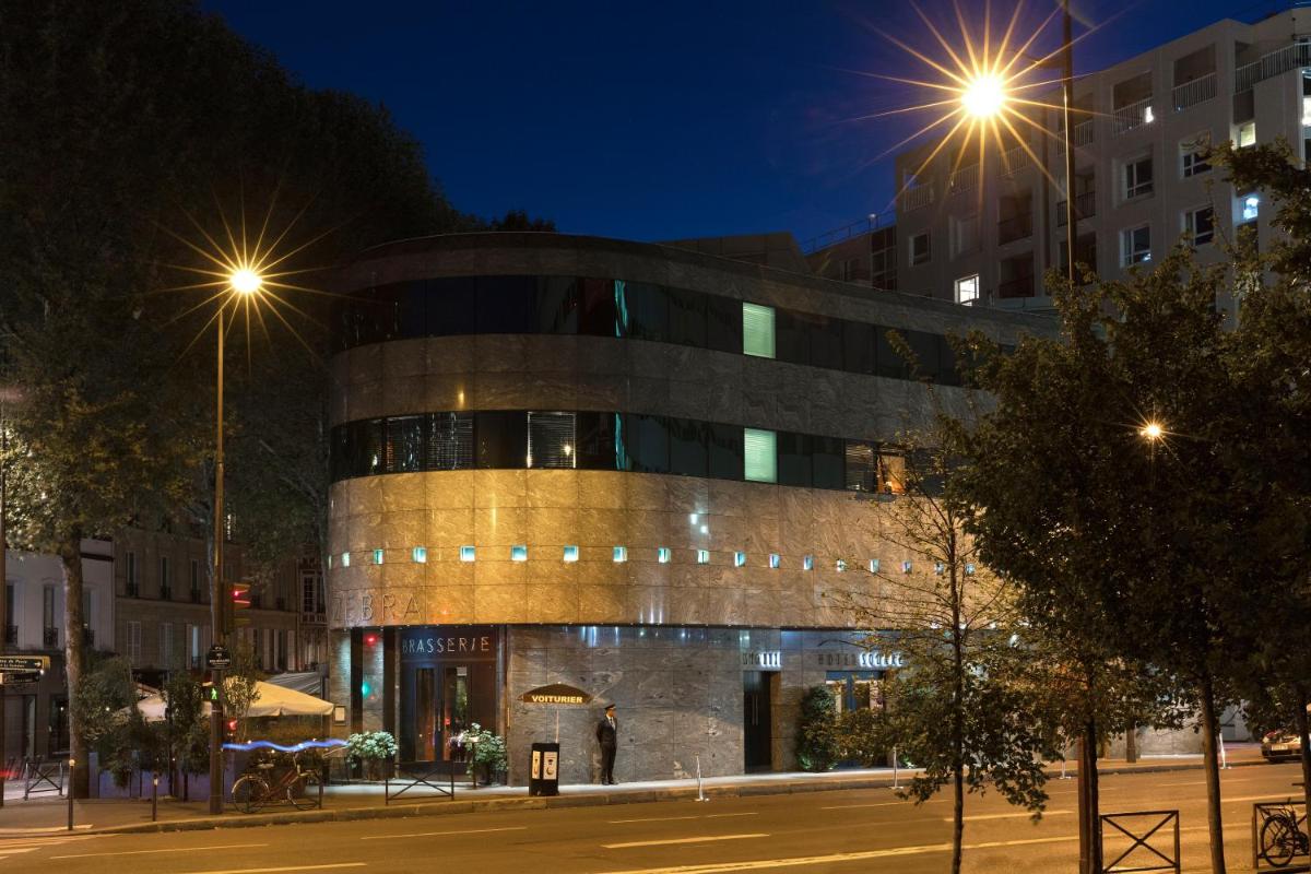 un bâtiment dans une rue la nuit avec des lampadaires dans l'établissement Hotel Square, à Paris