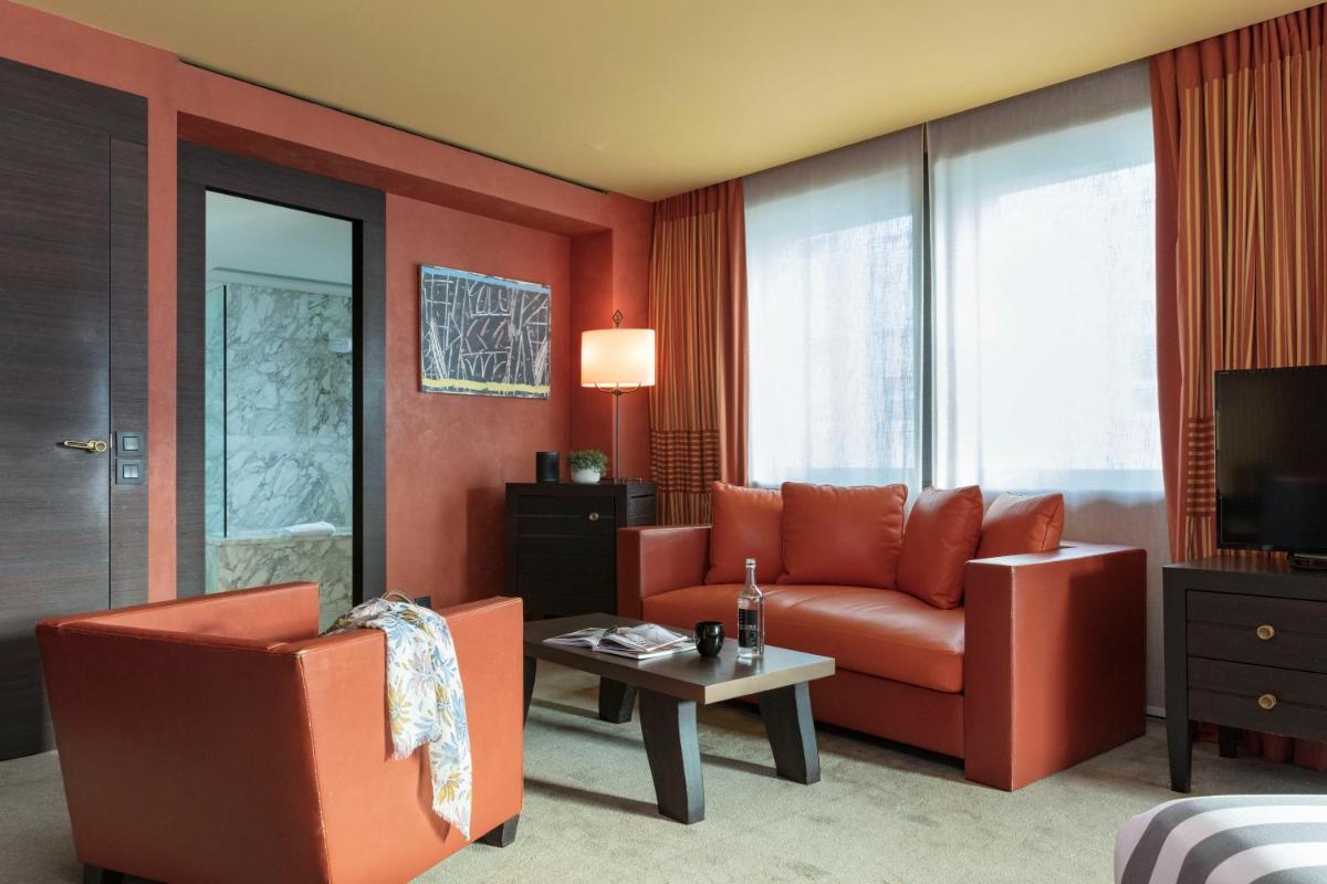 un salon avec un canapé orange et une table dans l'établissement Hotel Square, à Paris