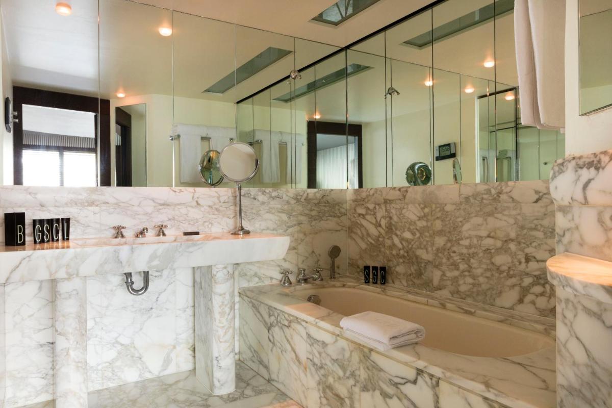 une salle de bains avec baignoire, lavabo et miroir dans l'établissement Hotel Square, à Paris 19 autres photos