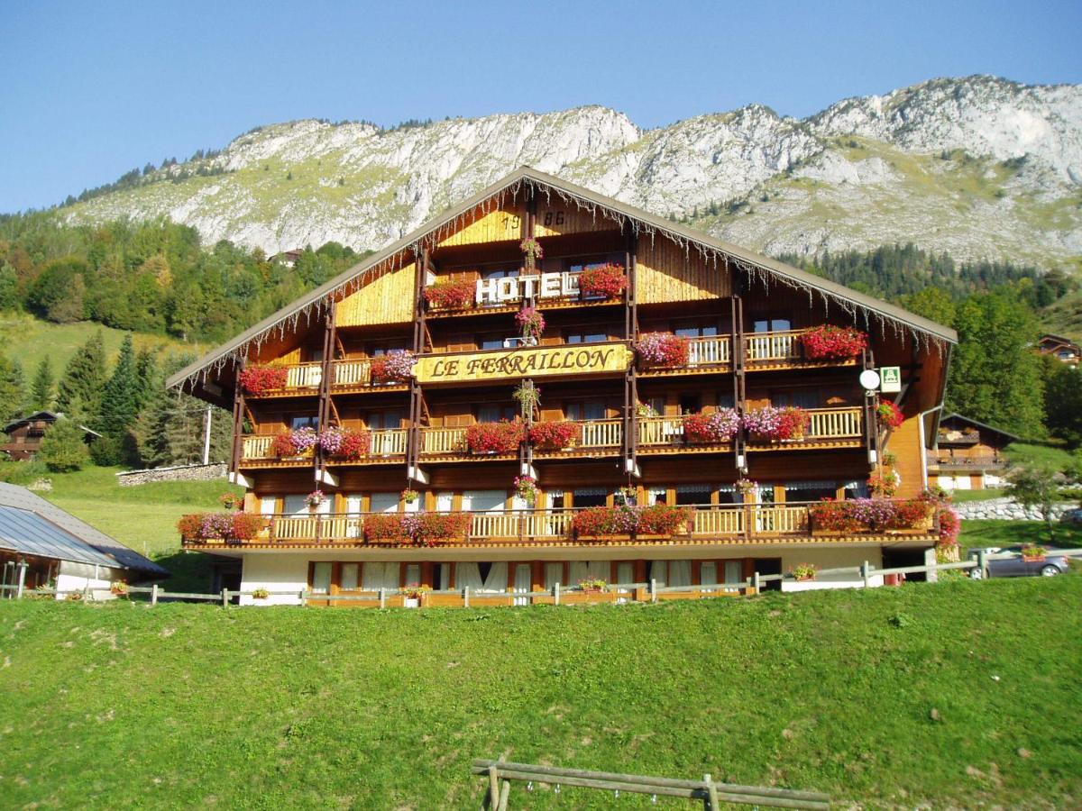 un grand bâtiment avec des fleurs sur son côté dans l'établissement Hotel Le Ferraillon, à Abondance