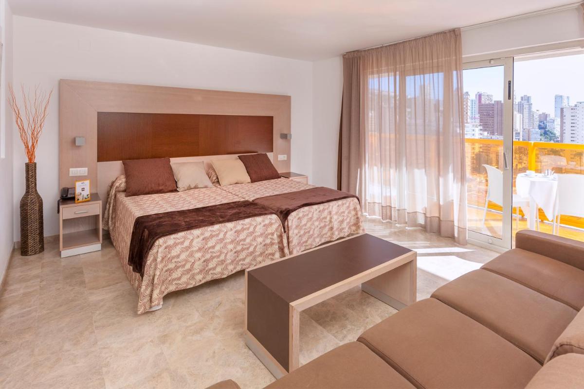 una habitación de hotel con una cama y un sofá en Hotel & SPA Dynastic, en Benidorm