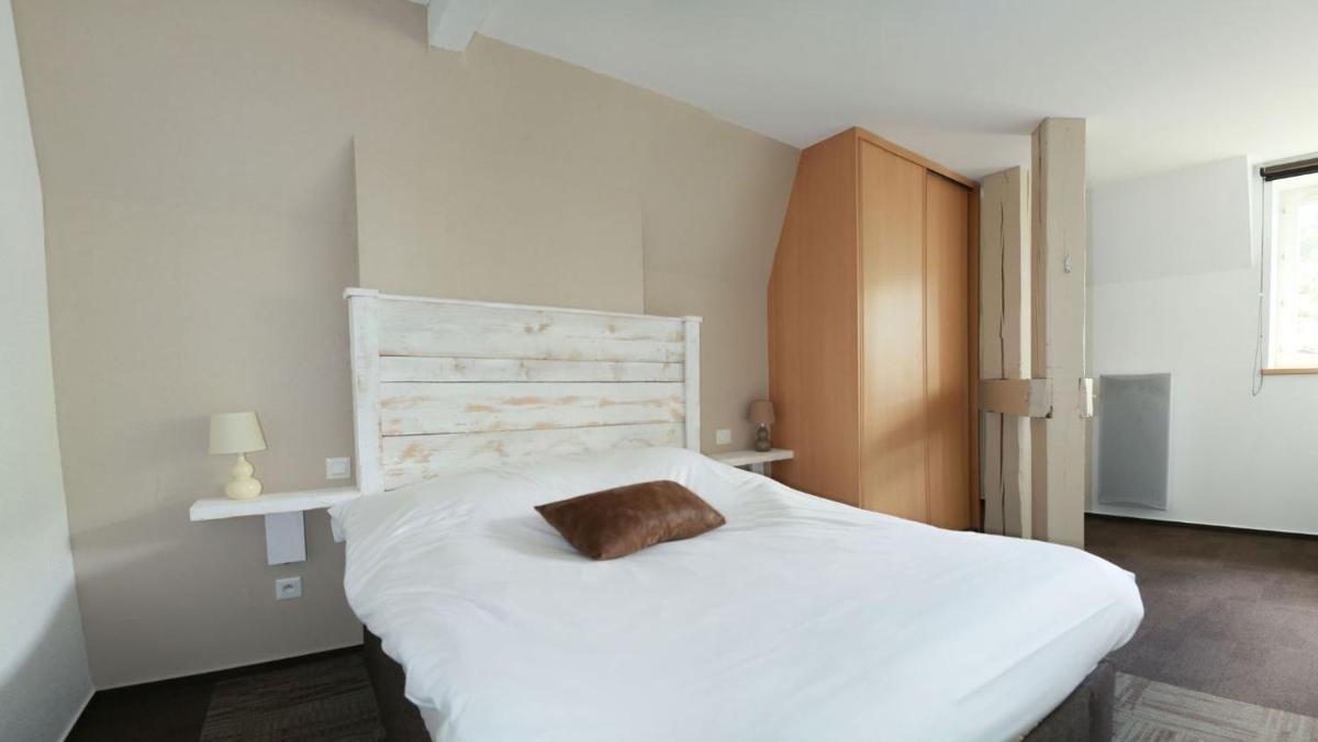 une chambre avec un lit blanc avec un oreiller dessus dans l'établissement La Demeure des 2 Trésors, à La Bresse