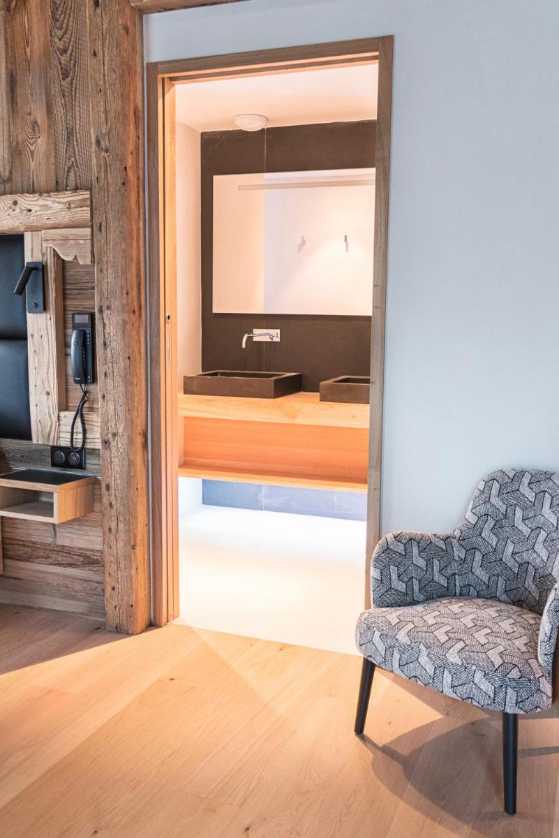 un salon avec une chaise et un miroir dans l'établissement Hôtel Interlaken Lounge Bar & Spa, à Xonrupt-Longemer