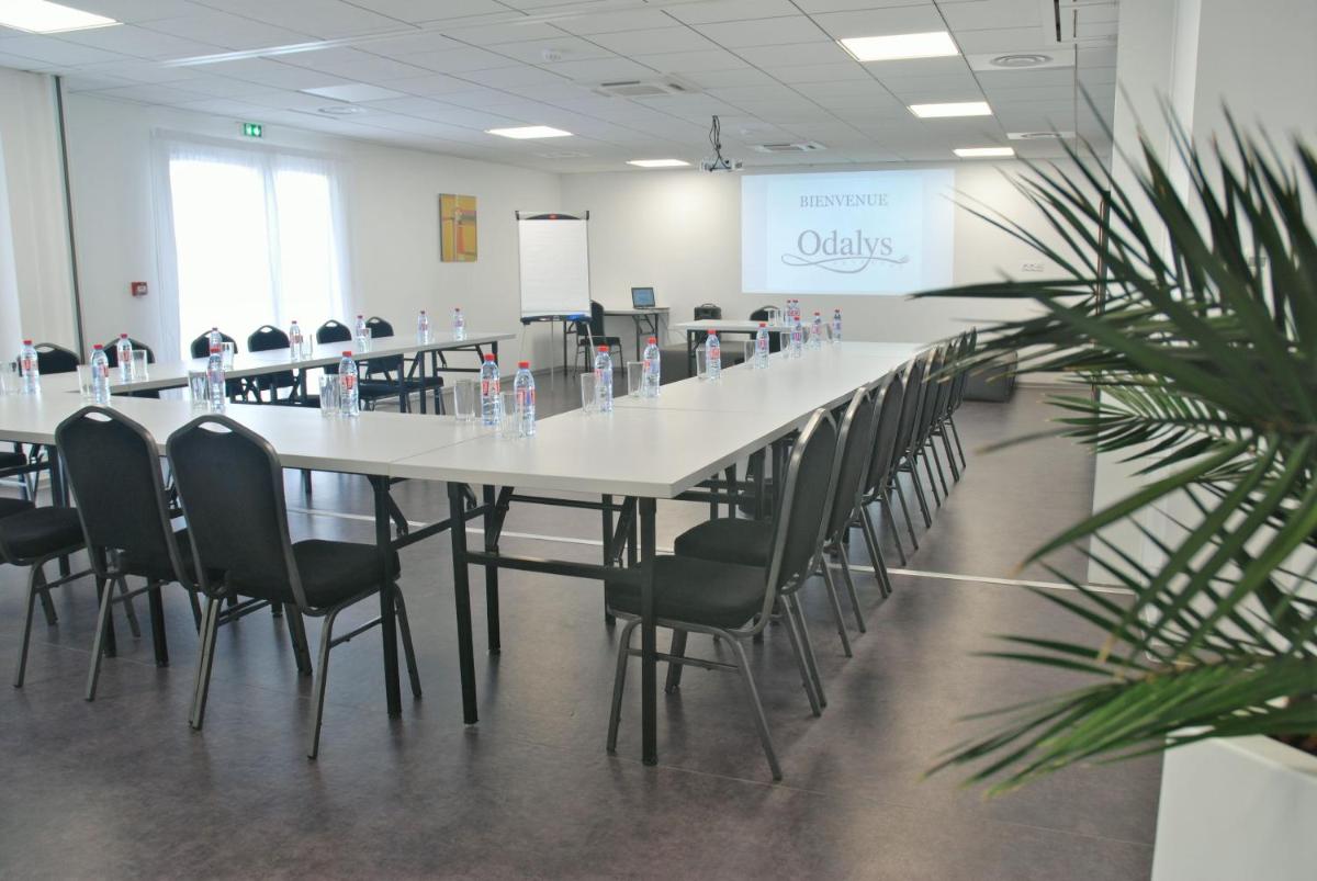 une salle de conférence avec une longue table et des chaises dans l'établissement Appart'Hotel Odalys Nakâra, au Cap d'Agde 23 autres photos