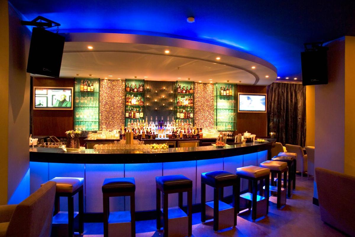 a bar in a restaurant with blue lighting at Taj MG Road Bengaluru in Bengaluru a bar in a restaurant with blue lighting at Taj MG Road Bengaluru in Bengaluru