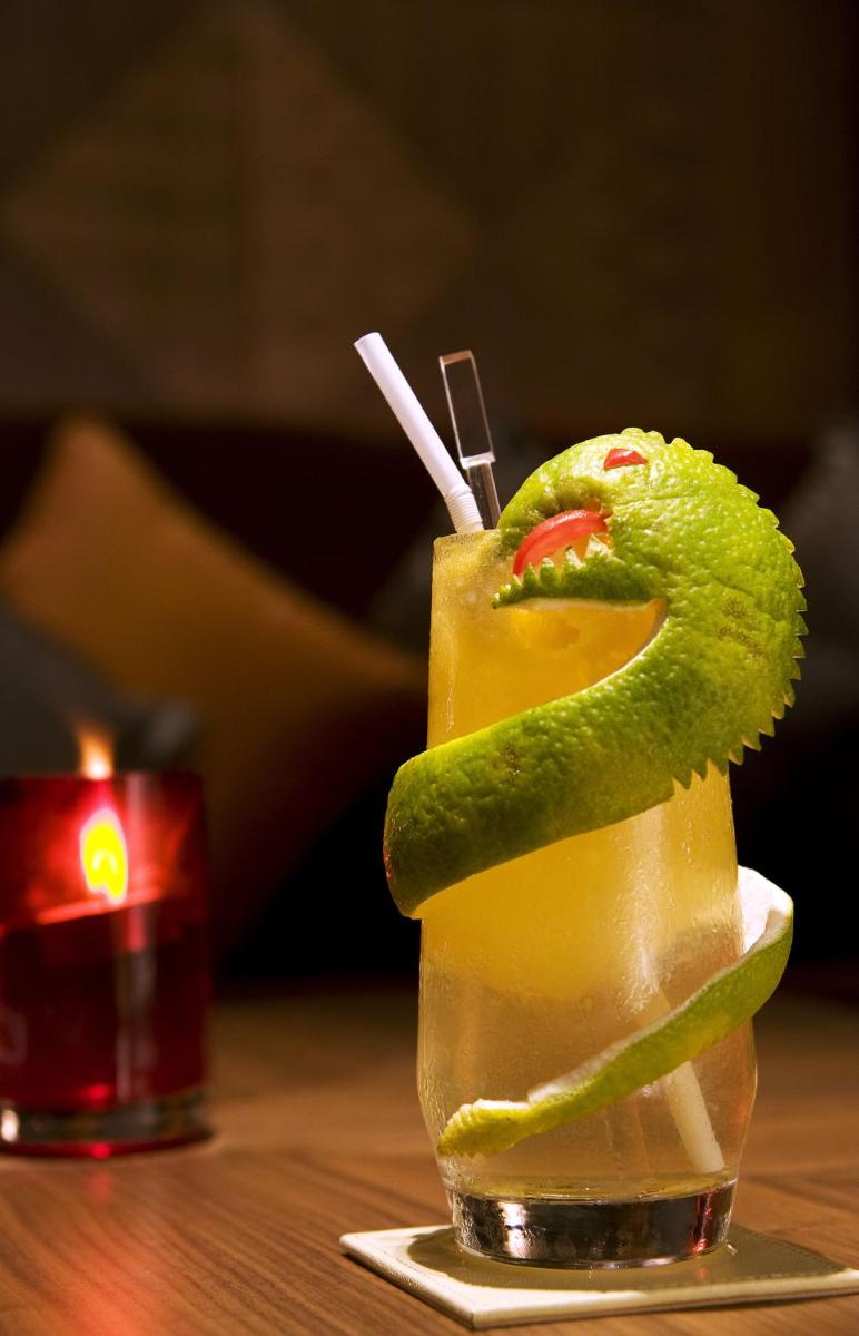 a drink with a snake on top of it on a table at Taj Coromandel in Chennai