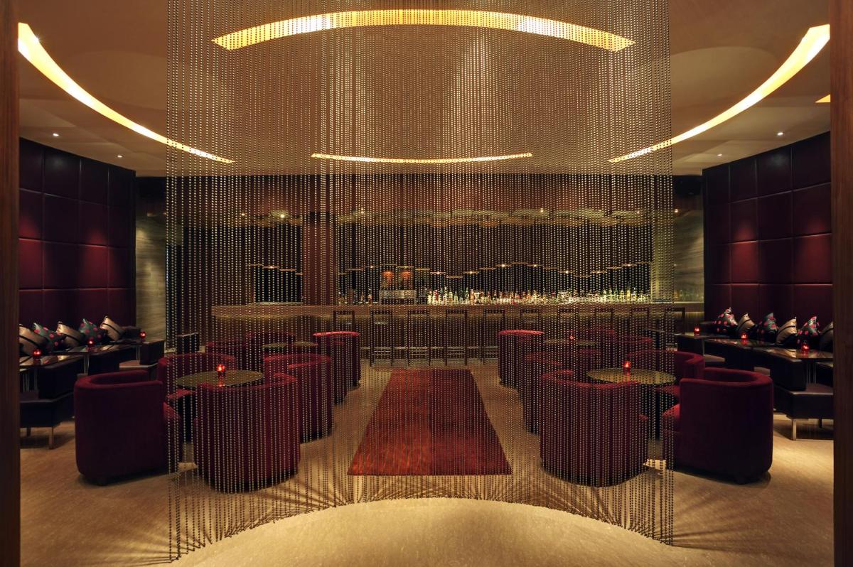 a restaurant with tables and chairs and a bar at Taj Coromandel in Chennai