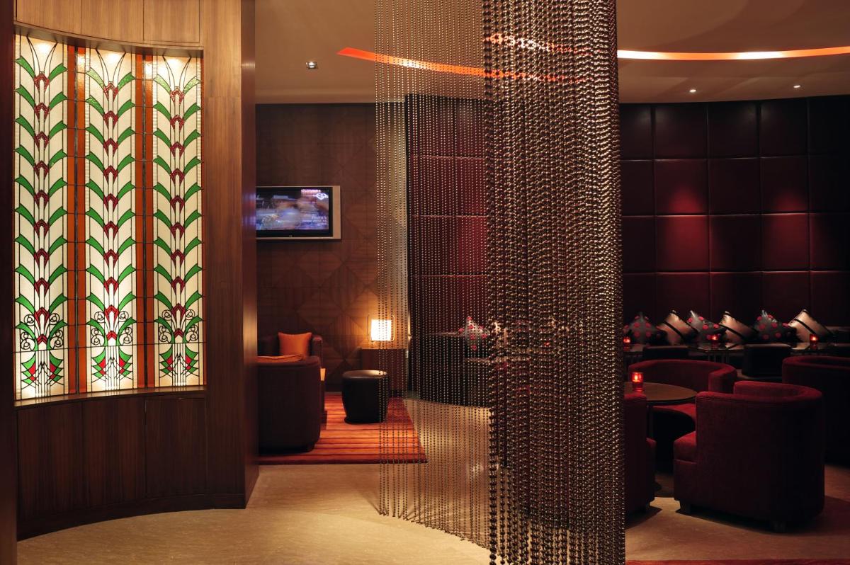 a lobby with a glass door with a waiting room at Taj Coromandel in Chennai