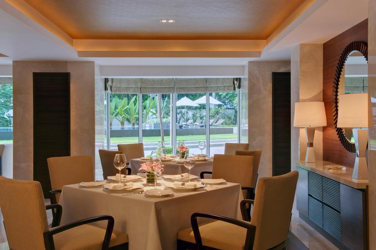a dining room with a table and chairs at Taj Coromandel in Chennai