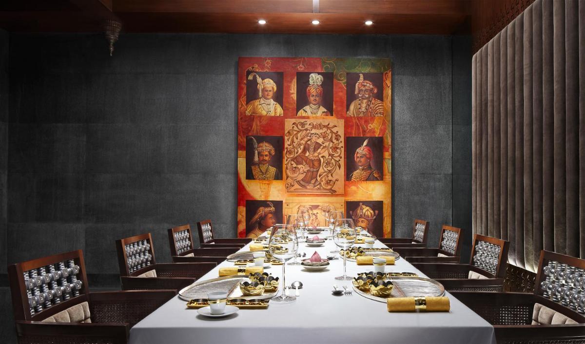 a dining room with a long table and chairs at Taj Coromandel in Chennai
