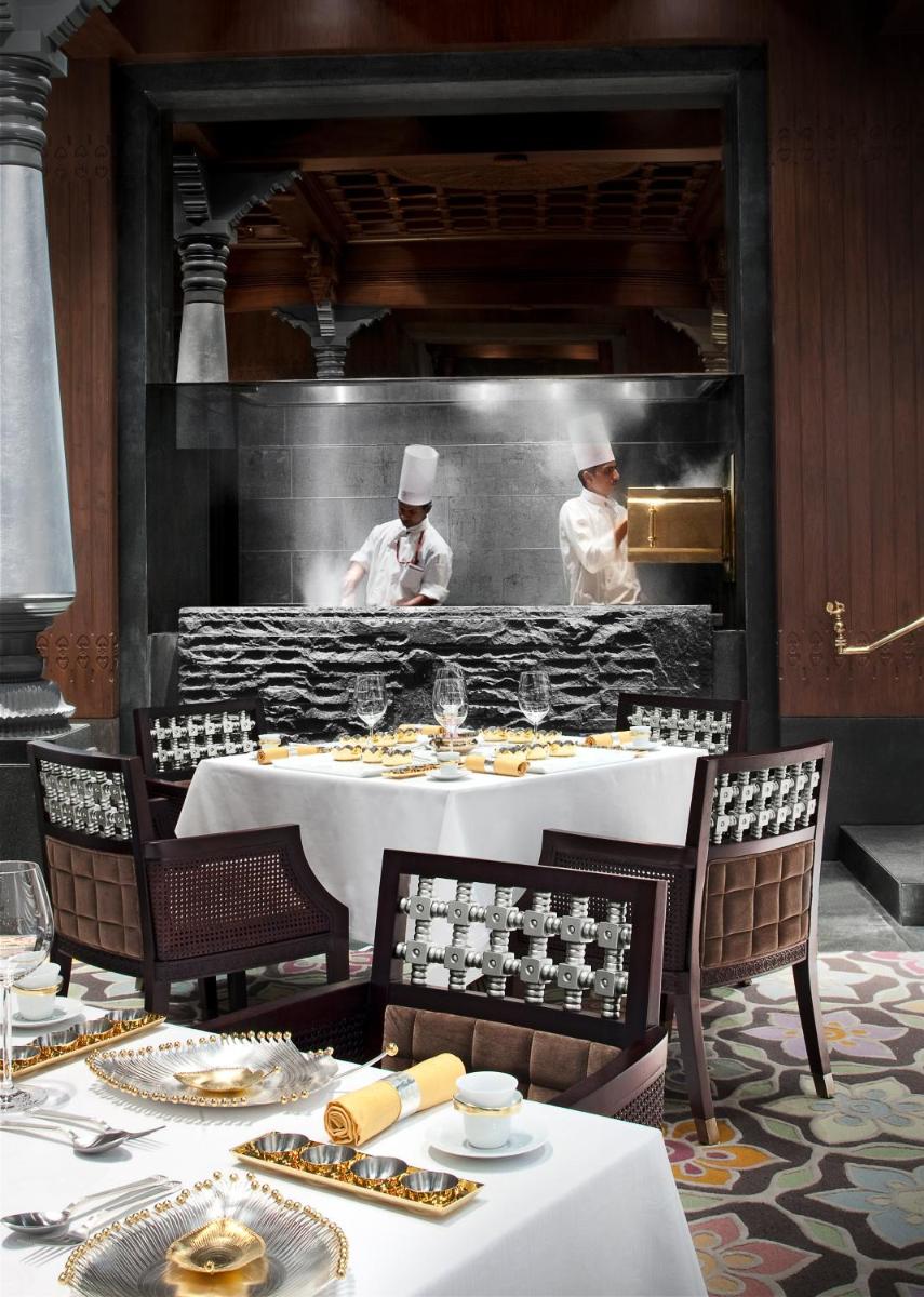 two chefs in a kitchen preparing food in a restaurant at Taj Coromandel in Chennai