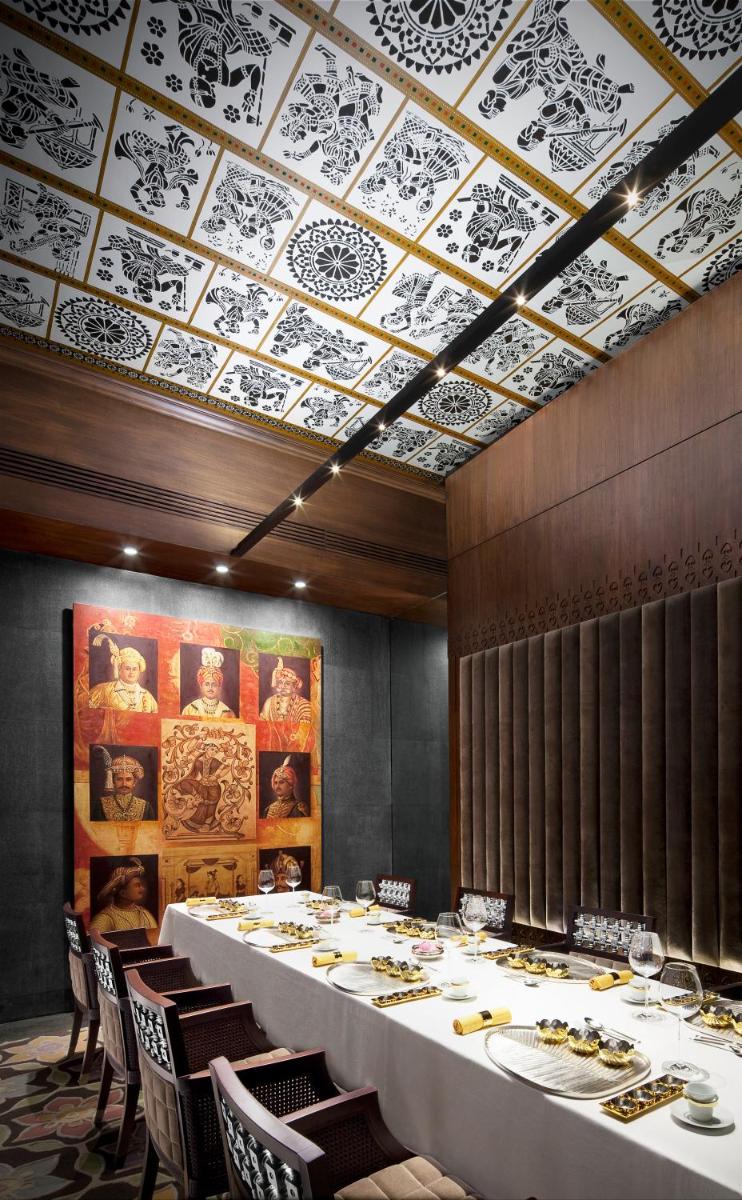 a dining room with a long table and chairs at Taj Coromandel in Chennai