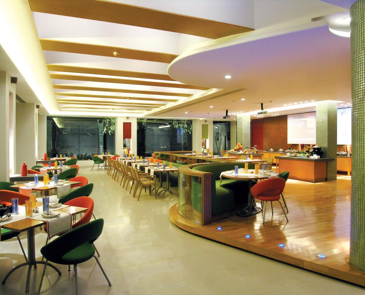 a restaurant with tables and chairs and a cafeteria at Taj Chandigarh in Chandīgarh