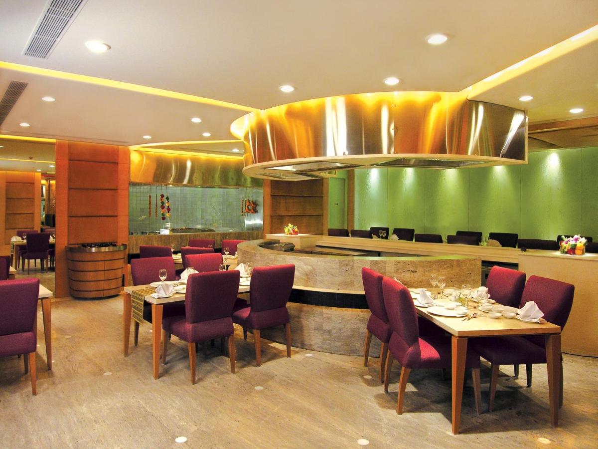 a restaurant with tables and chairs and a bar at Taj Chandigarh in Chandīgarh