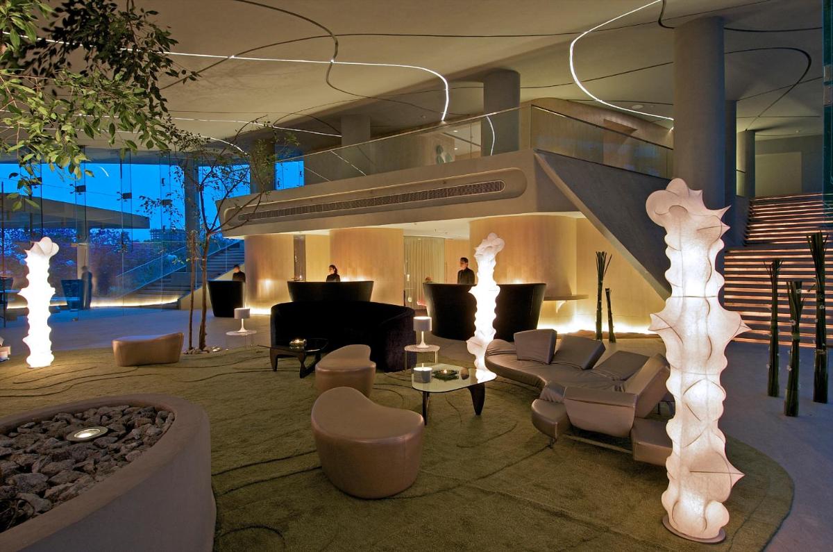 a living room with a couch and a piano at Vivanta Bengaluru, Whitefield in Bengaluru