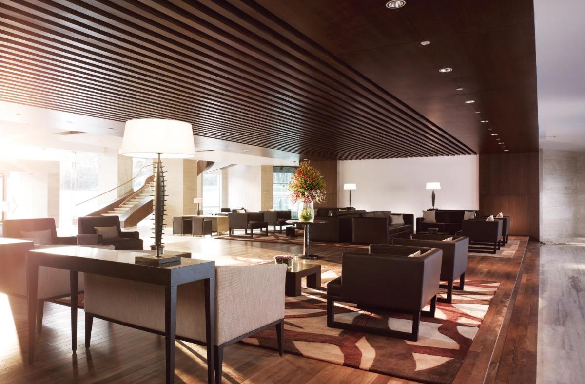 a lobby with couches and chairs in a building at Taj Yeshwantpur Bengaluru in Bengaluru a lobby with couches and chairs in a building at Taj Yeshwantpur Bengaluru in Bengaluru