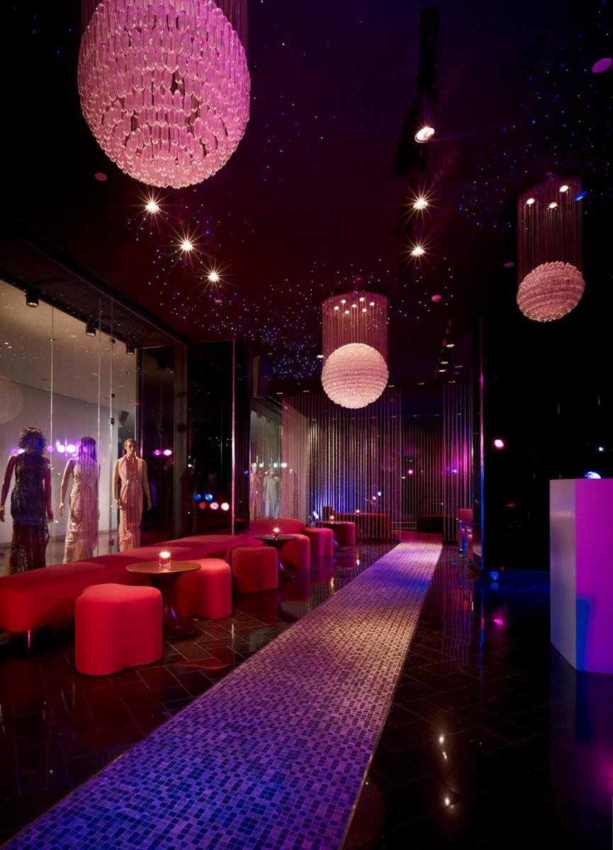 a room with red chairs and purple lighting and chandeliers at Taj Yeshwantpur Bengaluru in Bengaluru a room with red chairs and purple lighting and chandeliers at Taj Yeshwantpur Bengaluru in Bengaluru