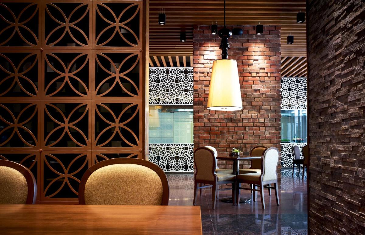 a dining room with a table and chairs and a brick wall at Taj Yeshwantpur Bengaluru in Bengaluru a dining room with a table and chairs and a brick wall at Taj Yeshwantpur Bengaluru in Bengaluru