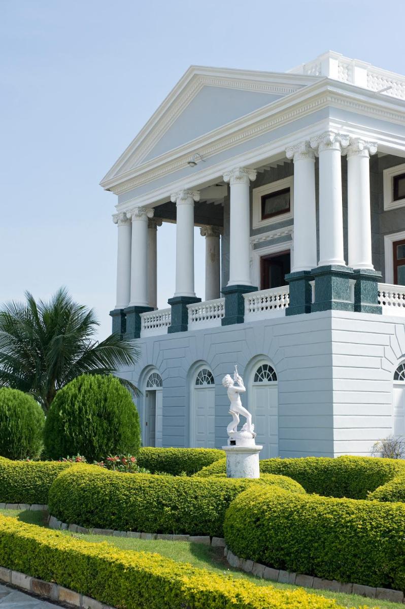 a white building with a statue in front of it at Taj Falaknuma Palace in Hyderabad