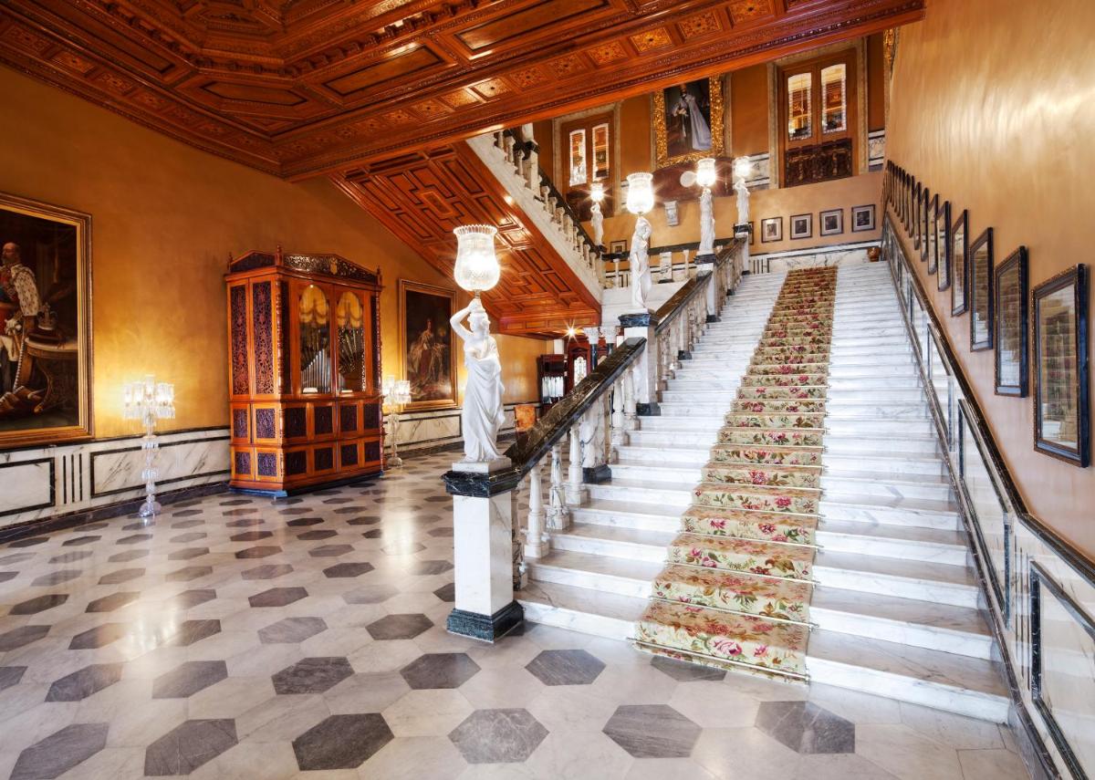 a staircase in a building with a statue in the middle at Taj Falaknuma Palace in Hyderabad