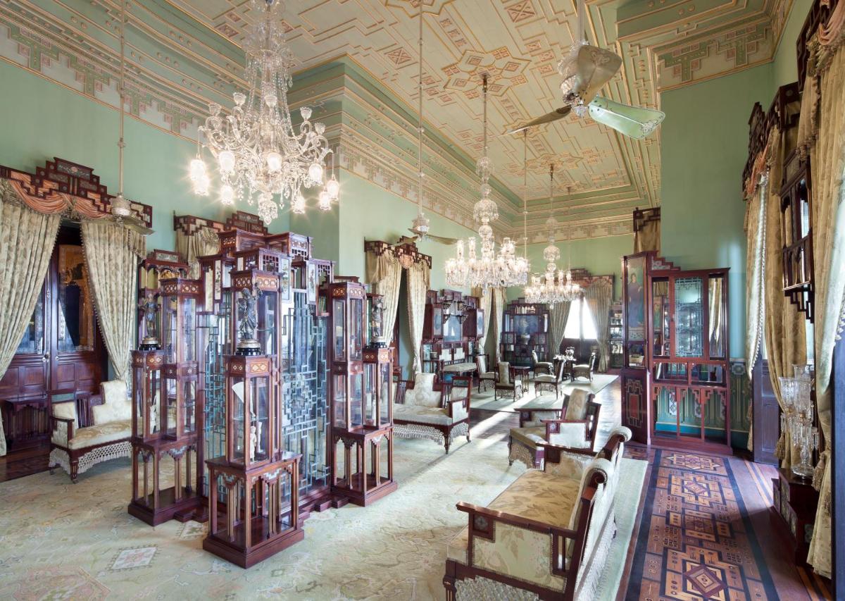 a room with chairs and tables and a chandelier at Taj Falaknuma Palace in Hyderabad
