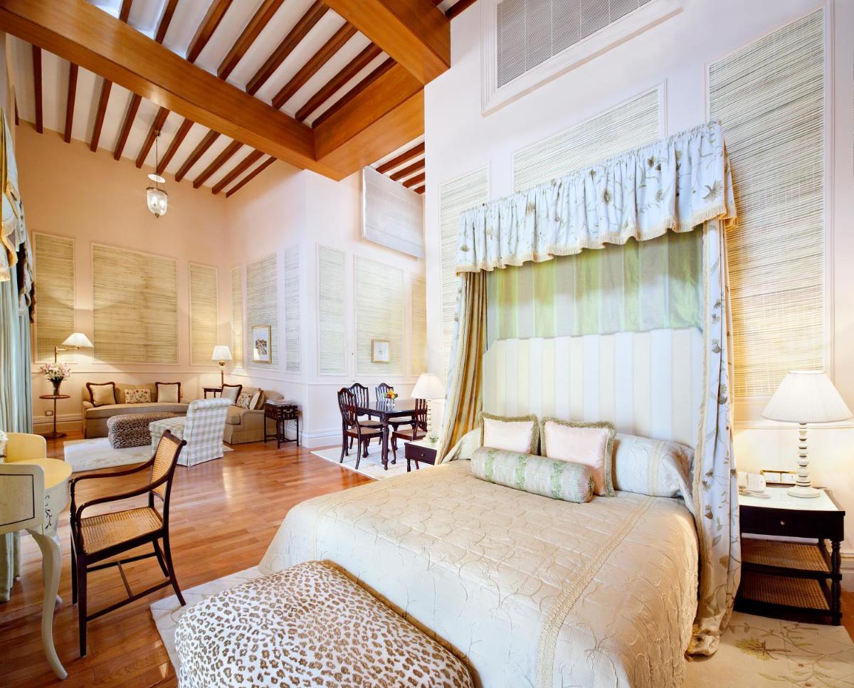 a bedroom with a bed and a living room at Taj Falaknuma Palace in Hyderabad