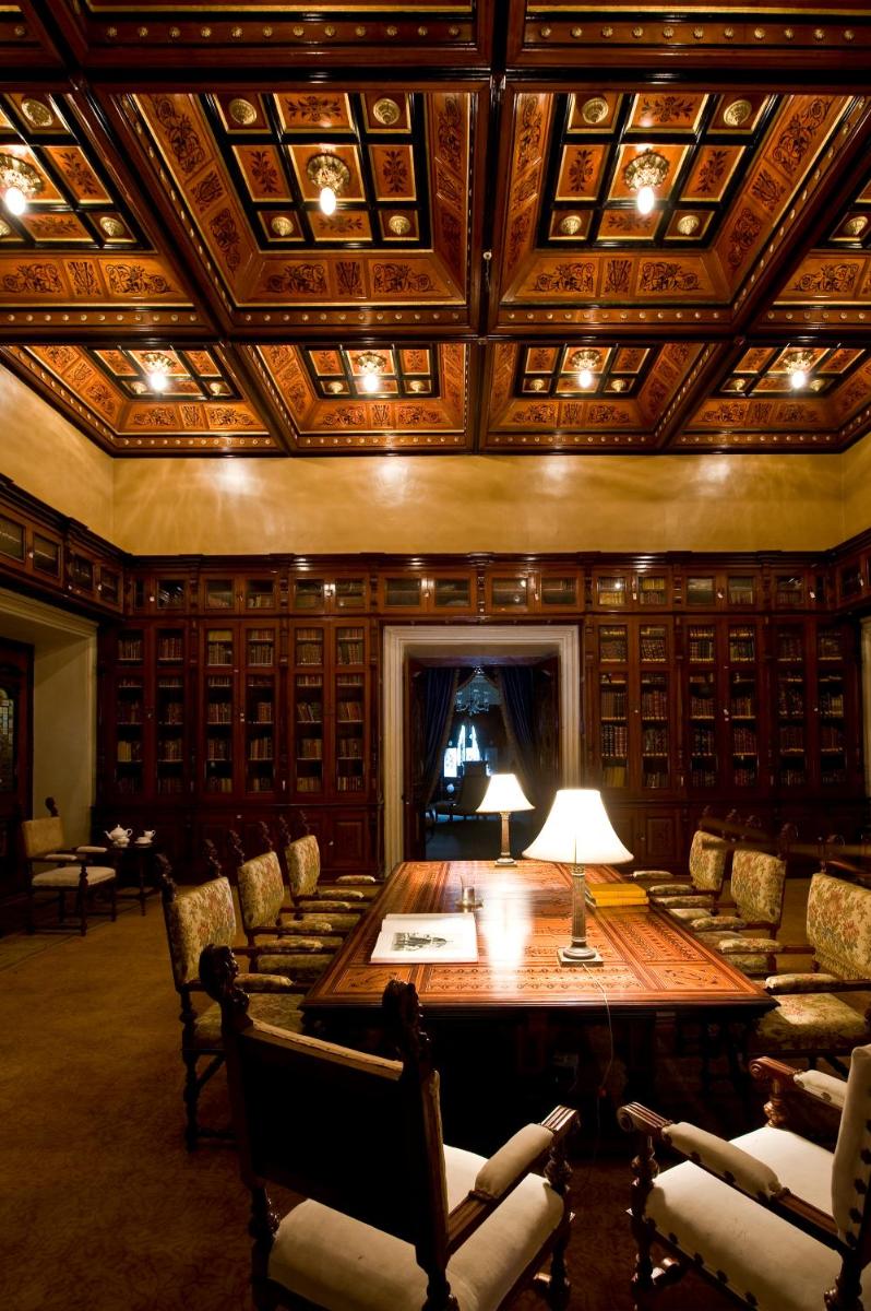 a large room with a large wooden table and chairs at Taj Falaknuma Palace in Hyderabad +51 photos