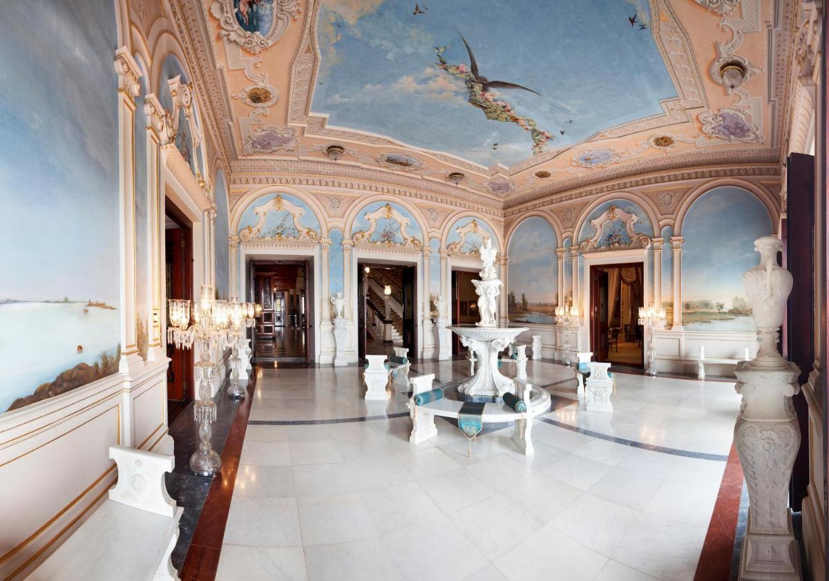 an ornate room with a ceiling and a tile floor at Taj Falaknuma Palace in Hyderabad