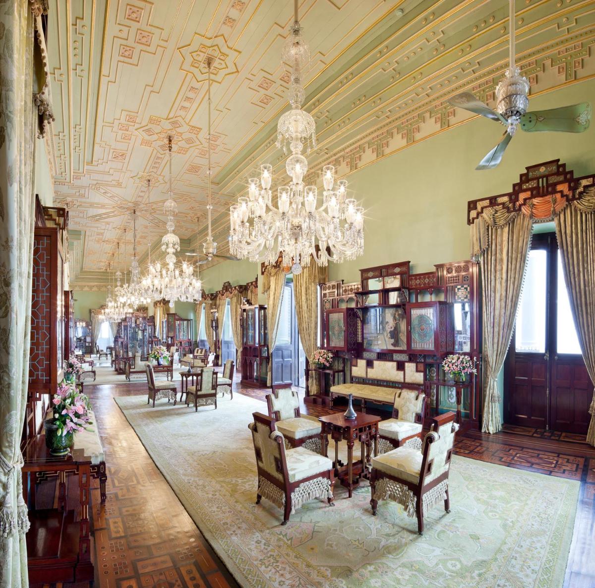 a large room with chairs and tables and a chandelier at Taj Falaknuma Palace in Hyderabad