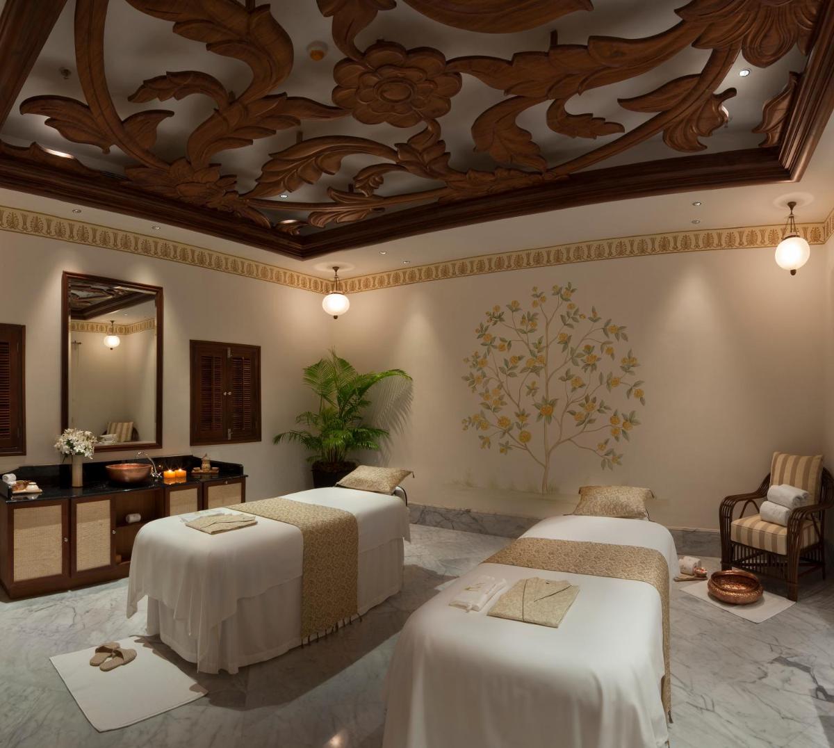 a hotel room with two beds and a ceiling at Taj Falaknuma Palace in Hyderabad