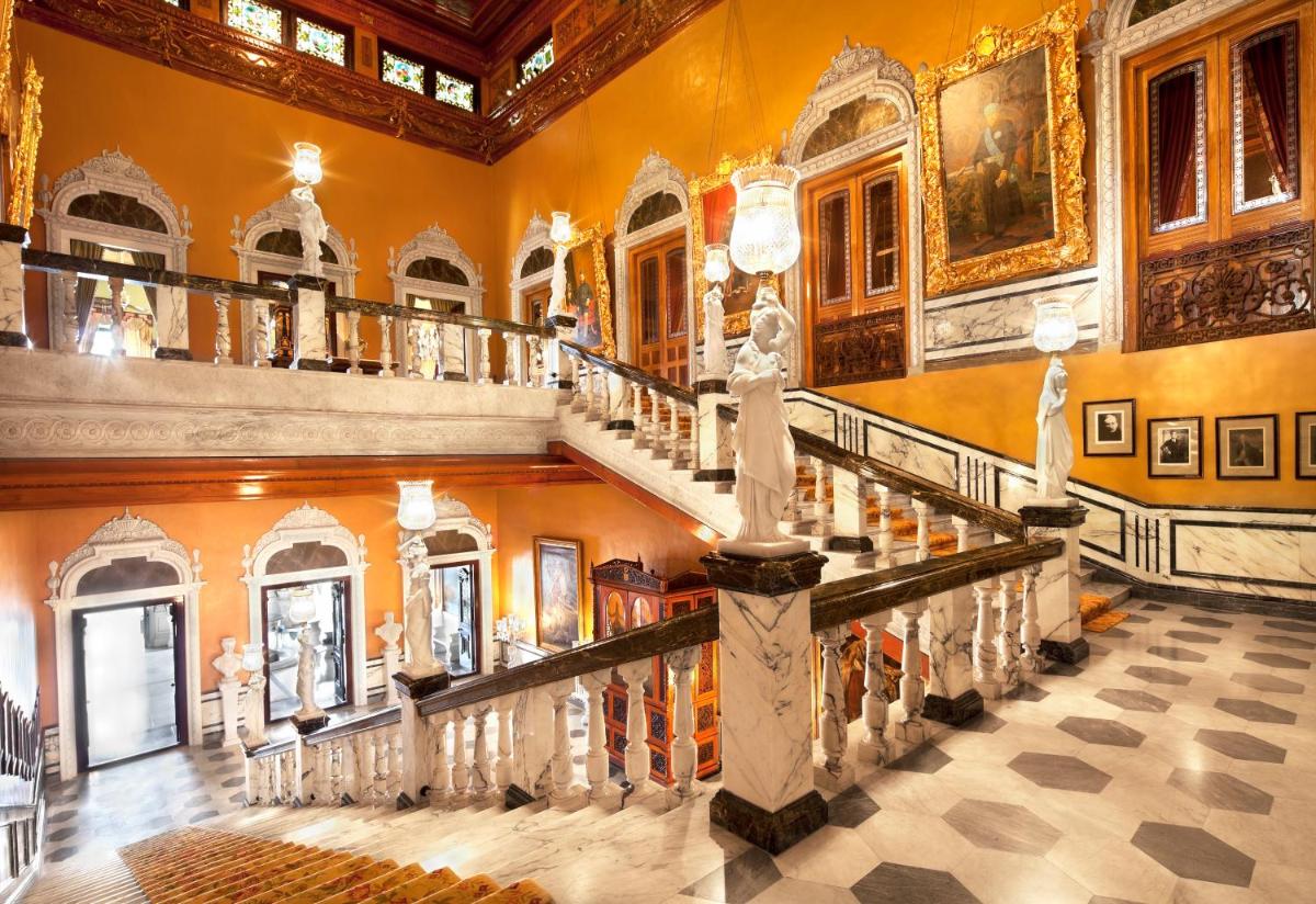 a staircase in a building with ornate ceilings at Taj Falaknuma Palace in Hyderabad