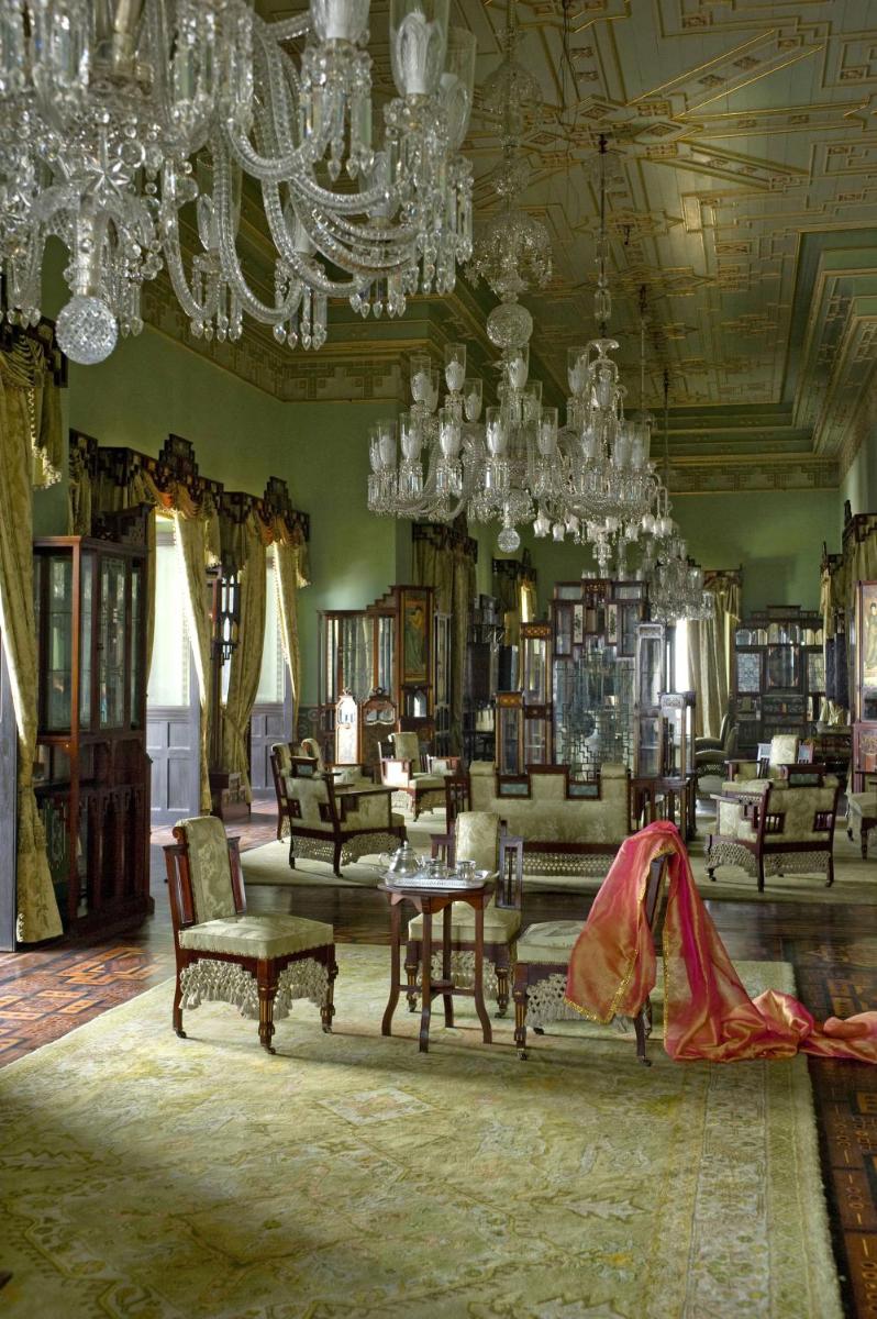 a living room with chandeliers and a room with furniture at Taj Falaknuma Palace in Hyderabad