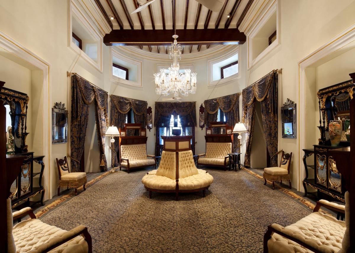 a large room with chairs and a chandelier at Taj Falaknuma Palace in Hyderabad