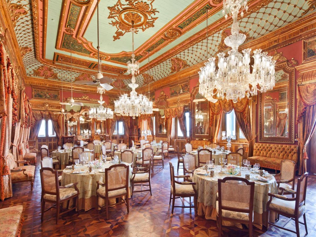 a dining room with tables and chandeliers at Taj Falaknuma Palace in Hyderabad